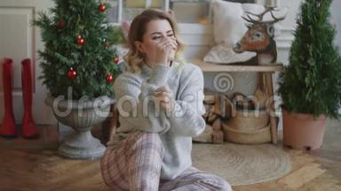 欧洲年轻迷人的女士穿着温暖的毛衣，坐在斯堪的纳维亚内部，舒适的圣诞家庭<strong>氛围</strong>和舒适的家庭<strong>氛围</strong>。